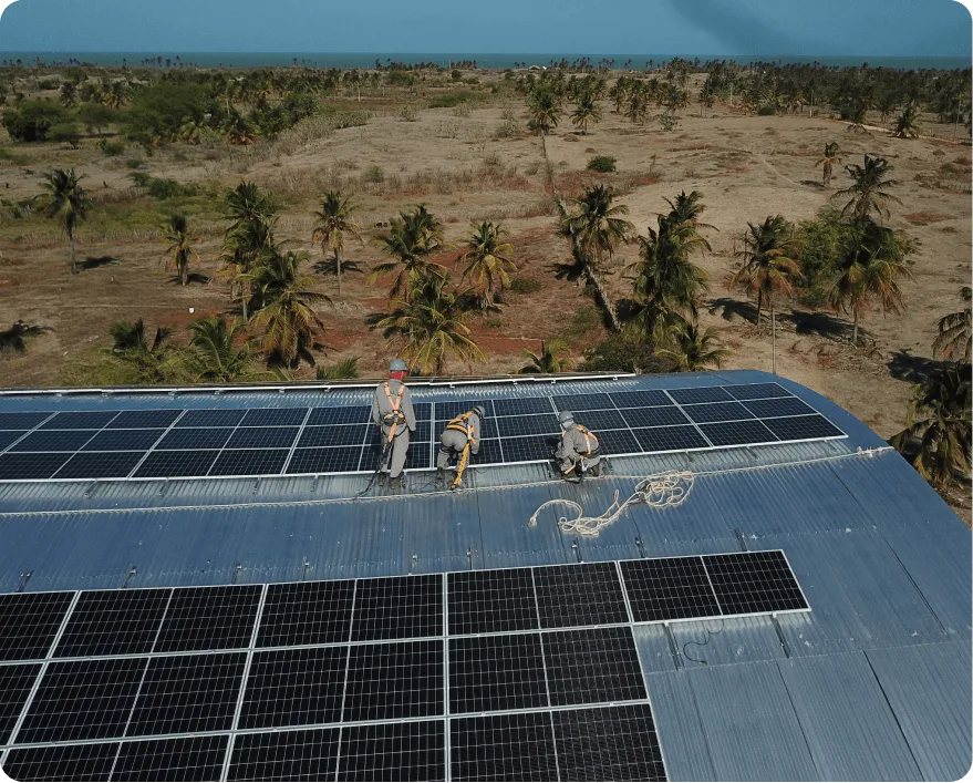 Equipe da Solls instalando painéis solares em telhado industrial, vista aérea