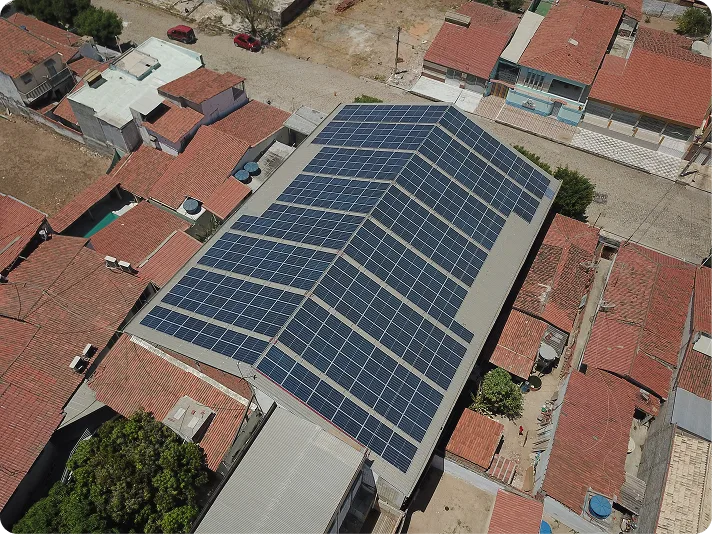 Usina solar instalada no telhado de um galpão comercial, vista aérea