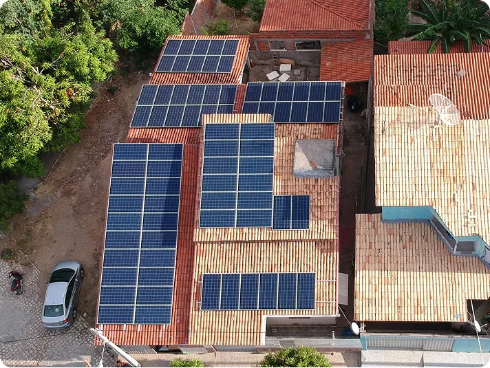 Sistema de energia solar instalado em telhado de residência, vista aérea